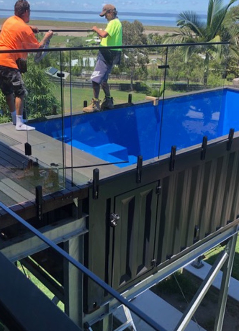 Glass balustrade being installed around an elevated container pool deck