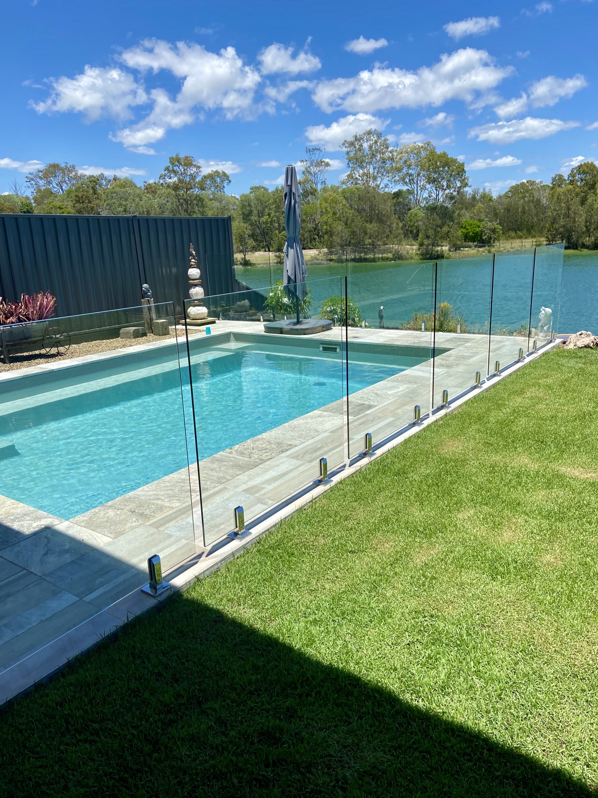 Frameless glass pool fencing beside a lakeside pool in coastal Queensland